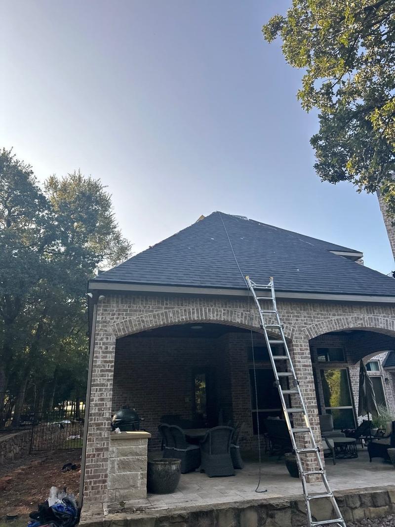 New shingle roof over a covered back patio on a brick home