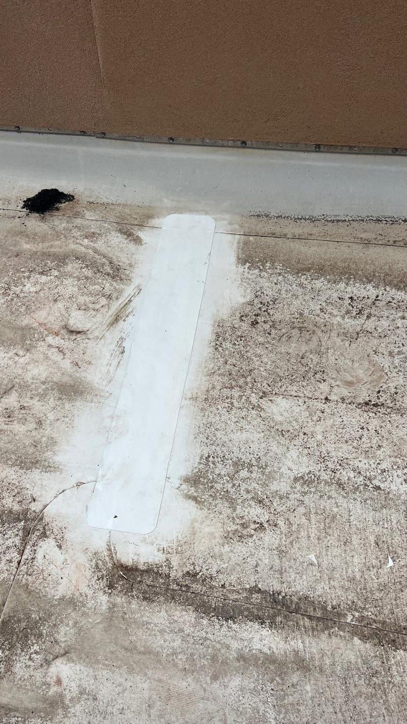Strip patch repair sealed over a worn flat roof before replacement